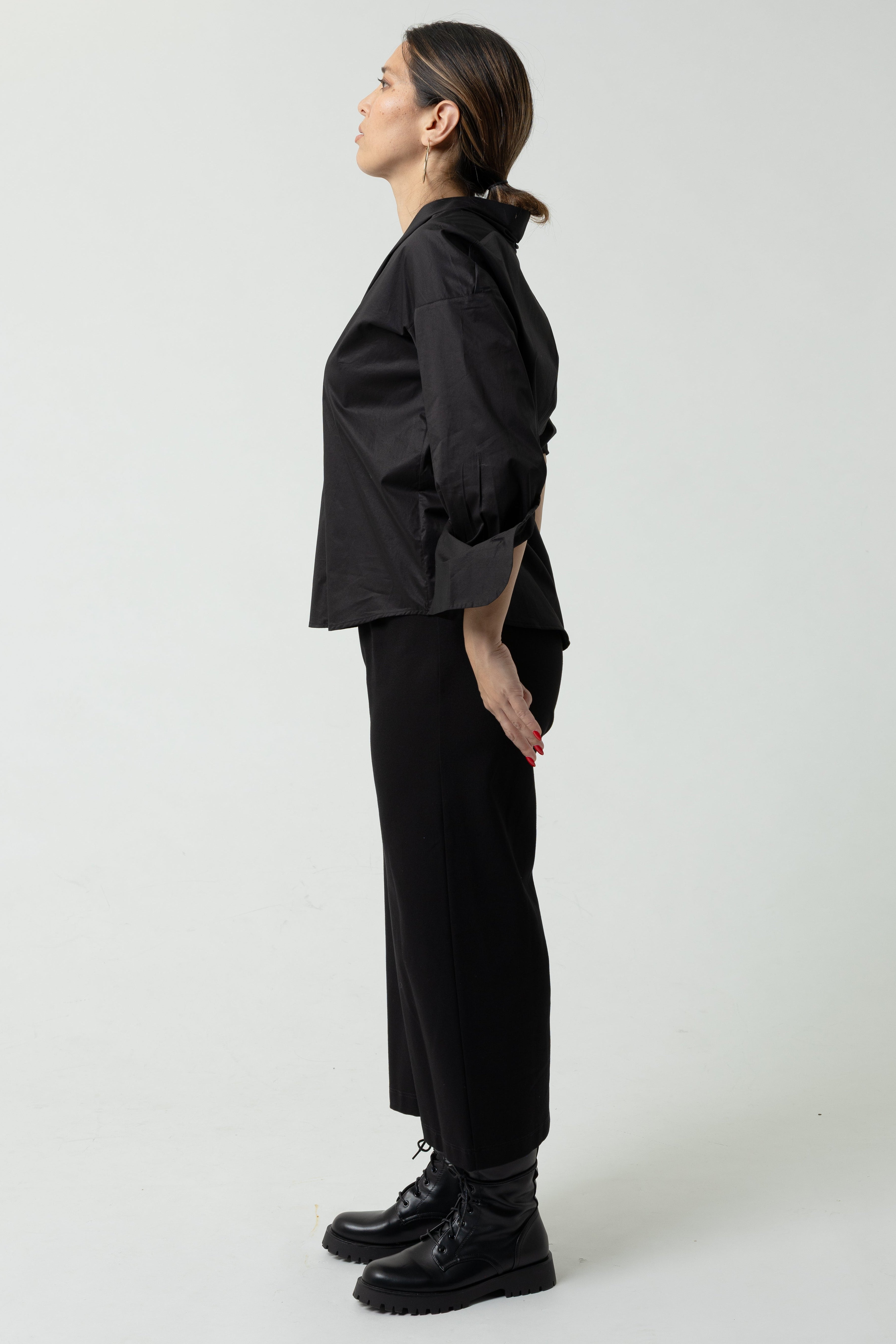 Person wearing a black outfit on a white background