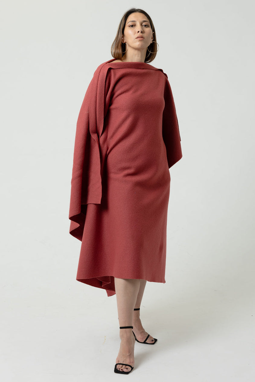 Woman wearing a red dress with a draped effect on a white background