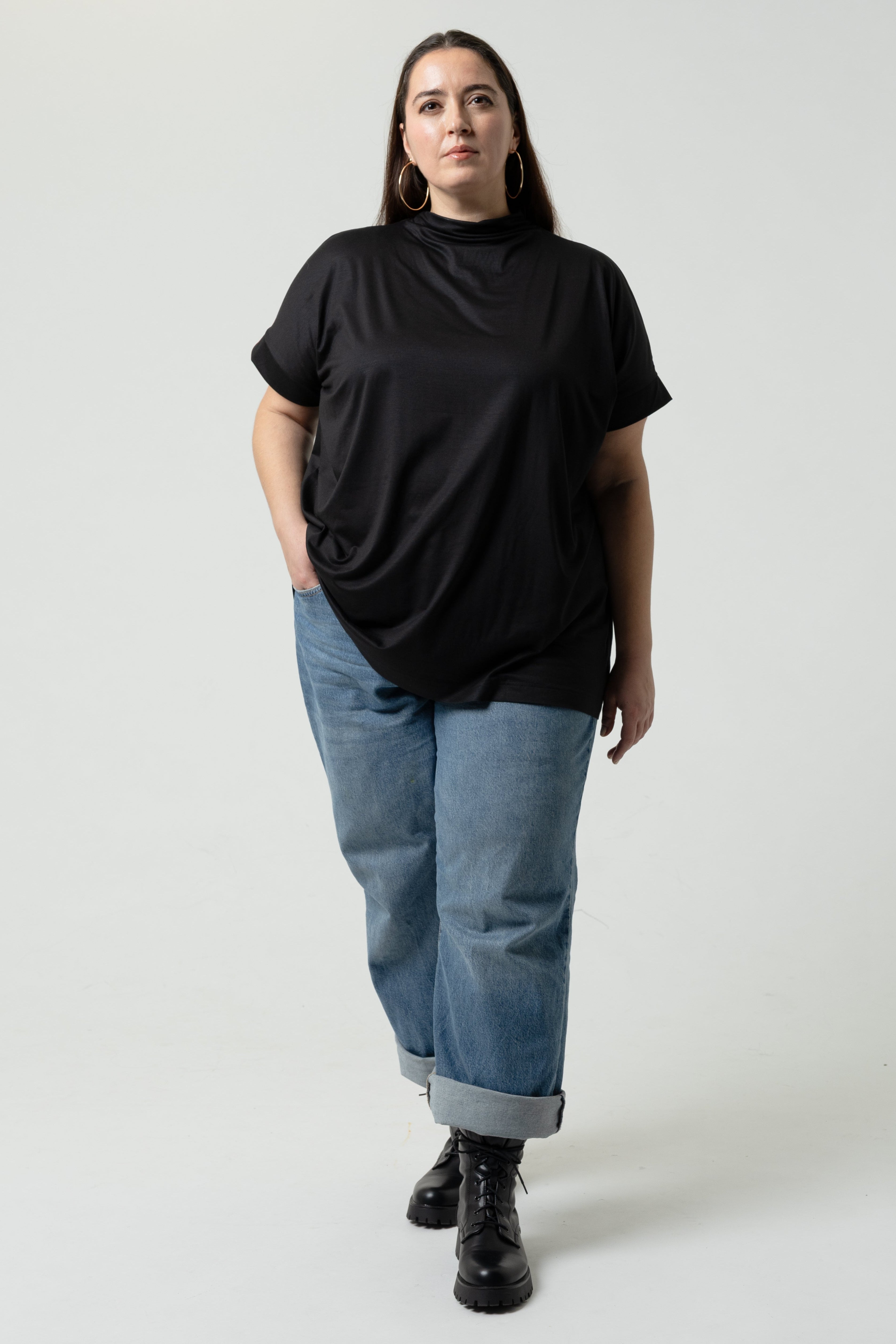 Person wearing a black t-shirt and blue jeans on a white background