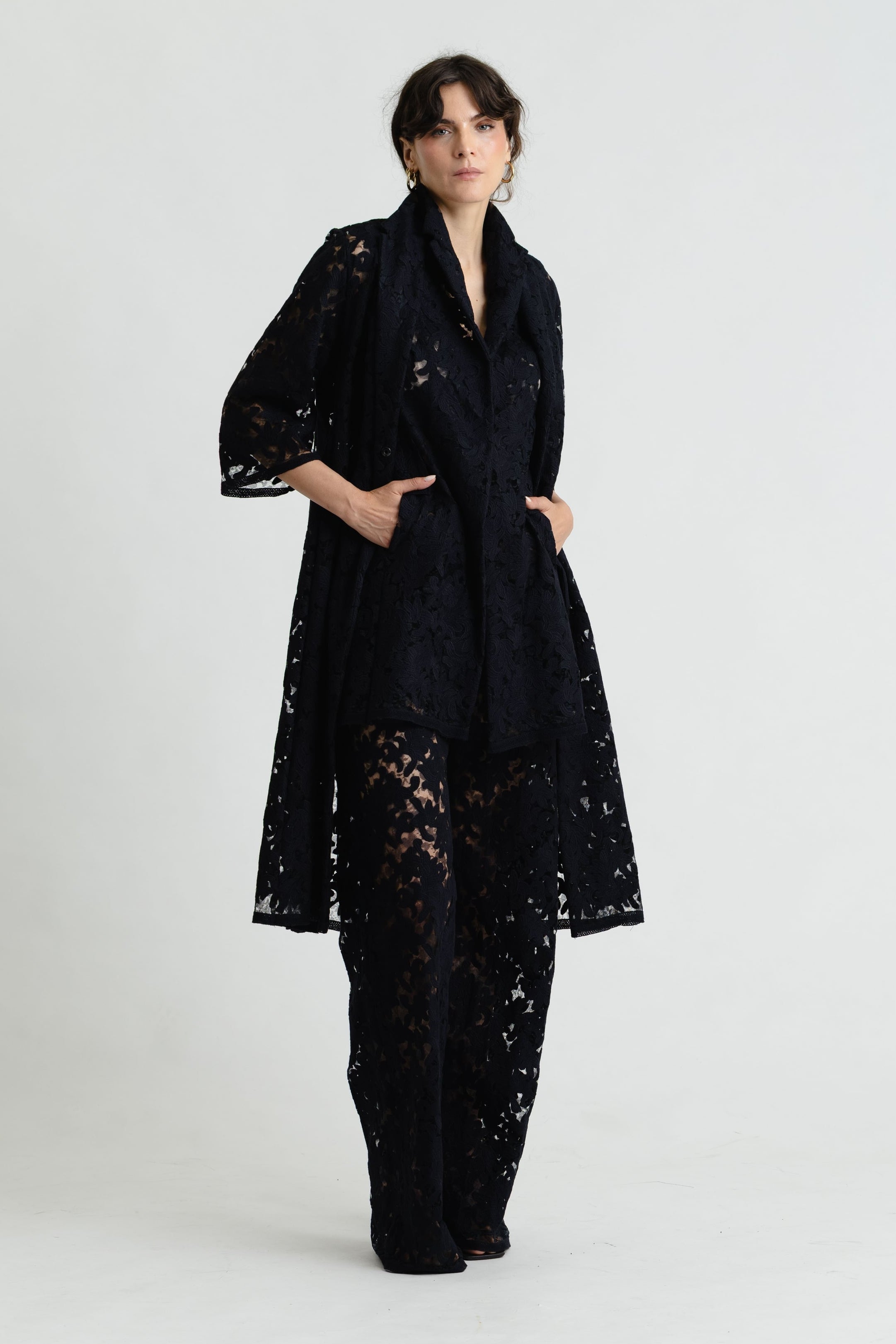 Woman wearing a black lace outfit on a white background