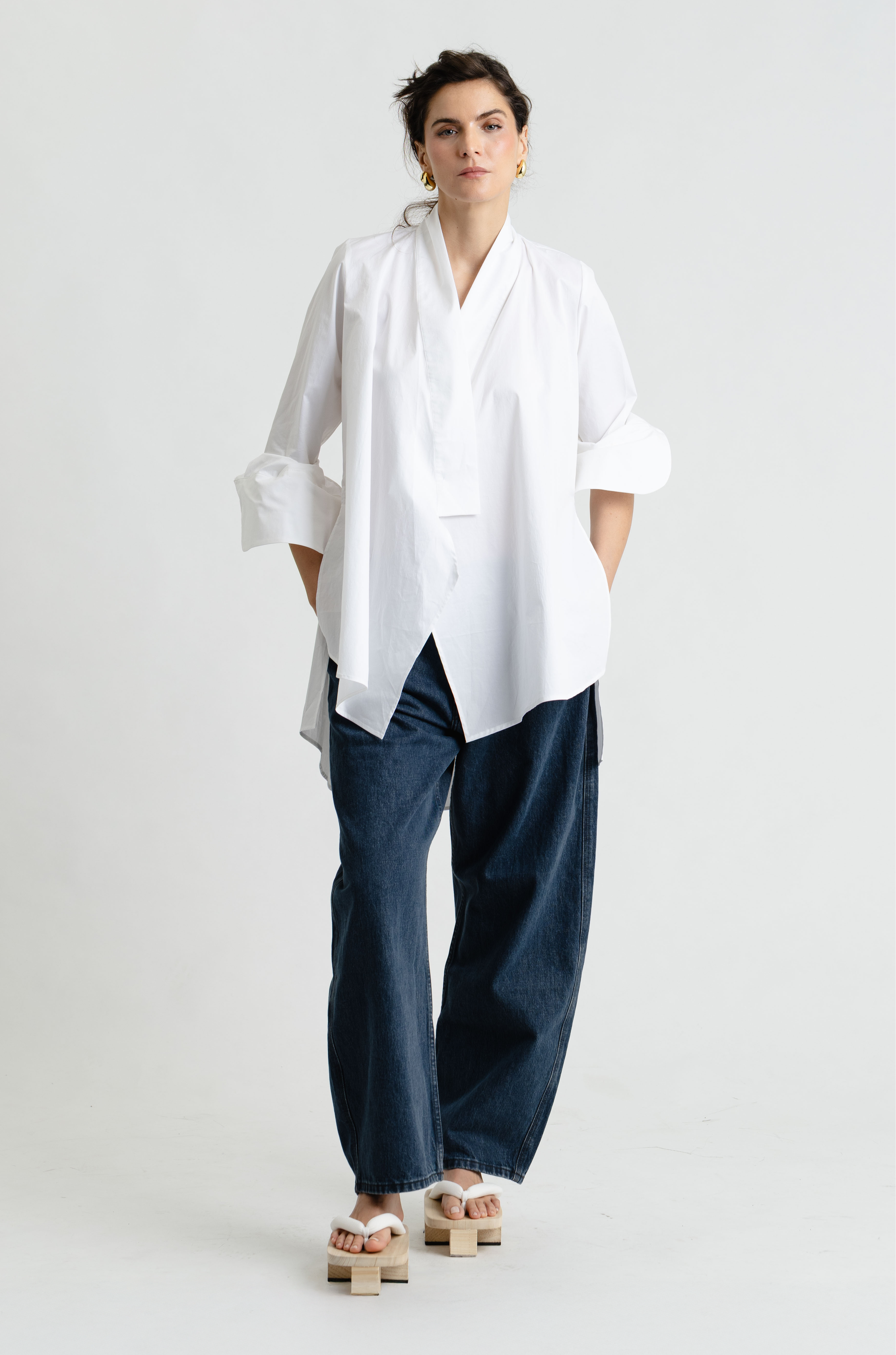 Person wearing a white shirt and blue pants on a white background