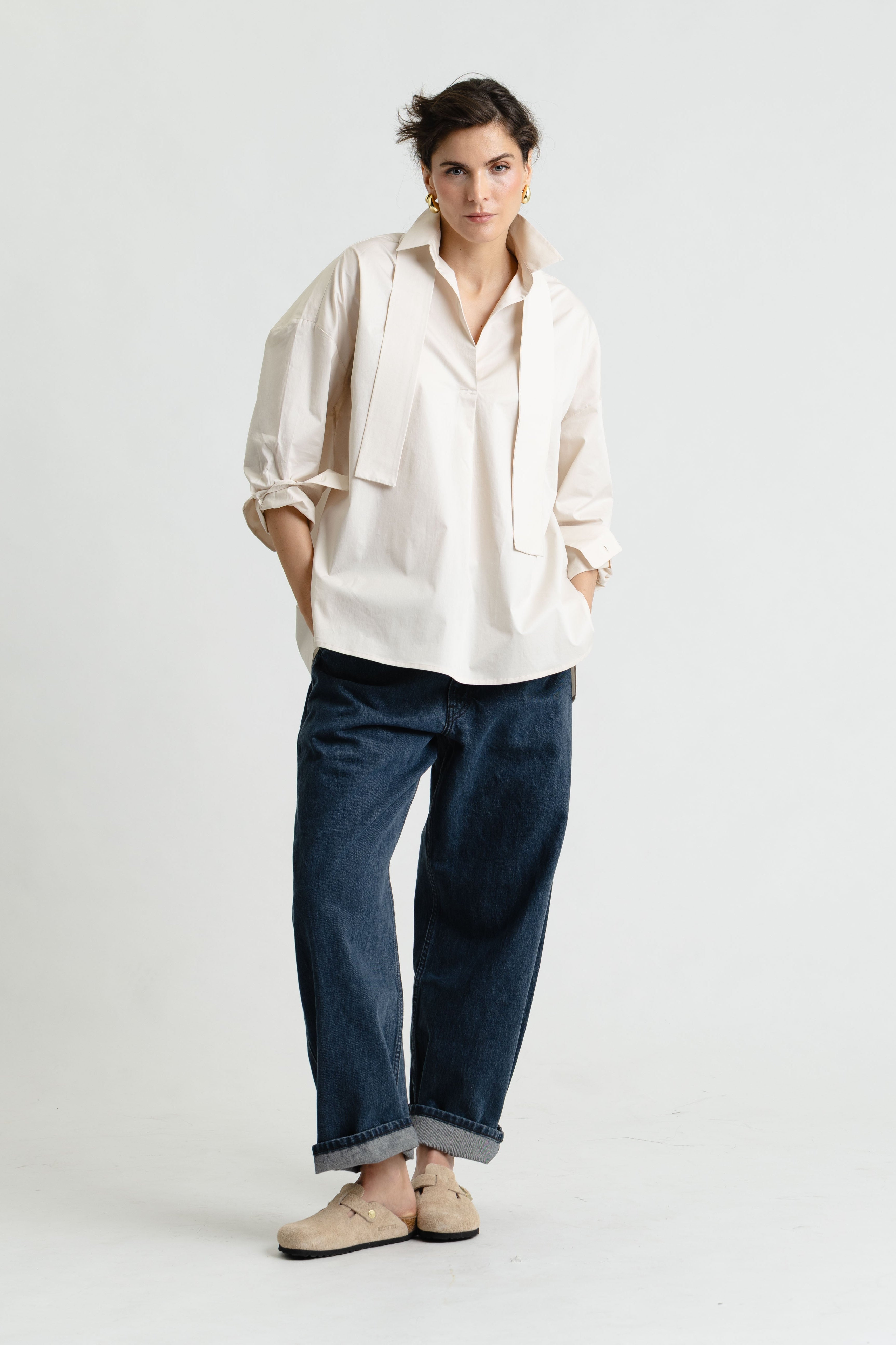 Person wearing a white shirt and blue jeans on a white background