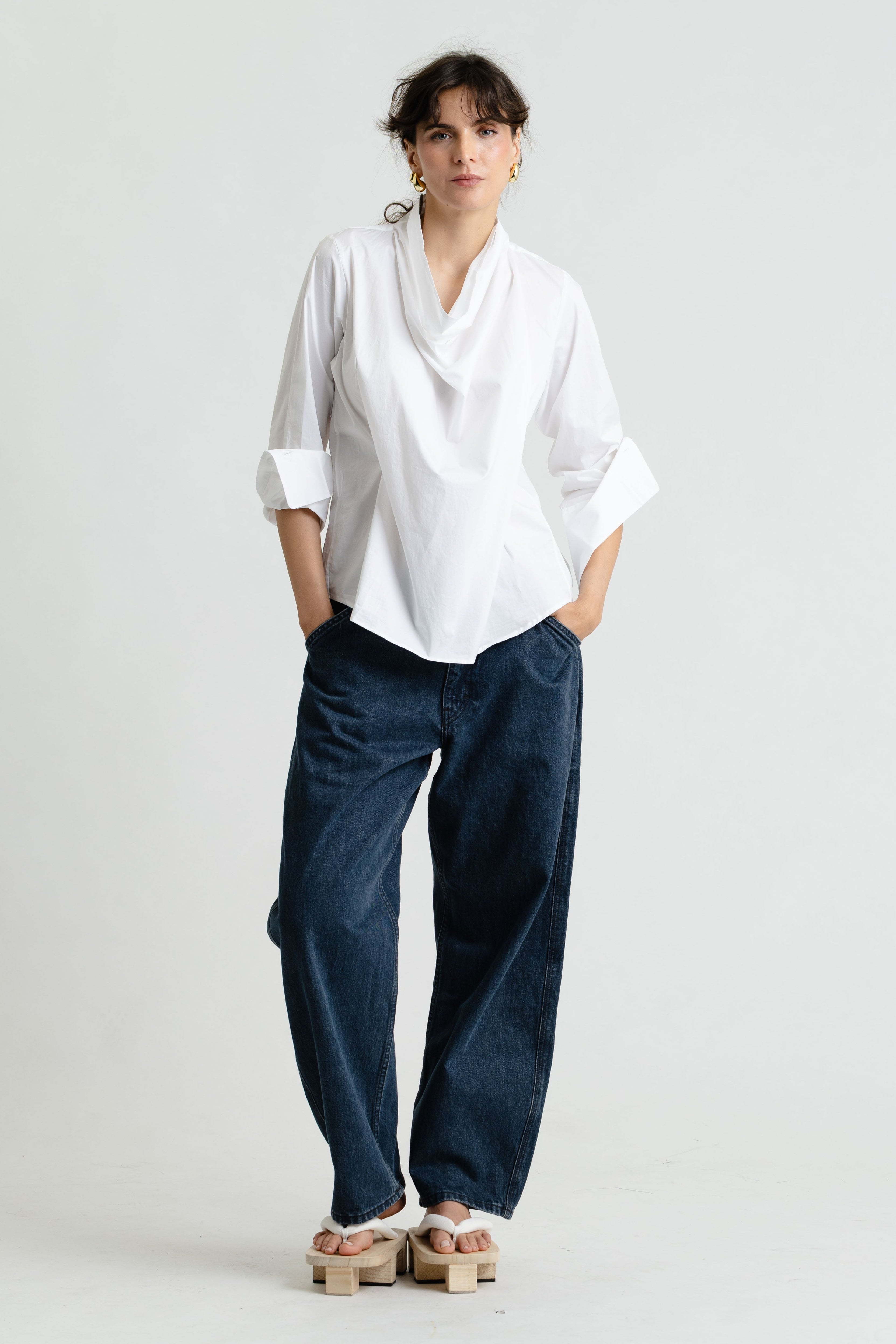 Person wearing a white shirt and navy pants on a white background