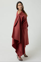 Woman wearing a red draped garment on a white background