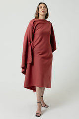 Woman wearing a red dress with a draped effect on a white background