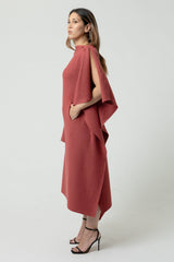 Woman wearing a red dress with a cape effect on a white background