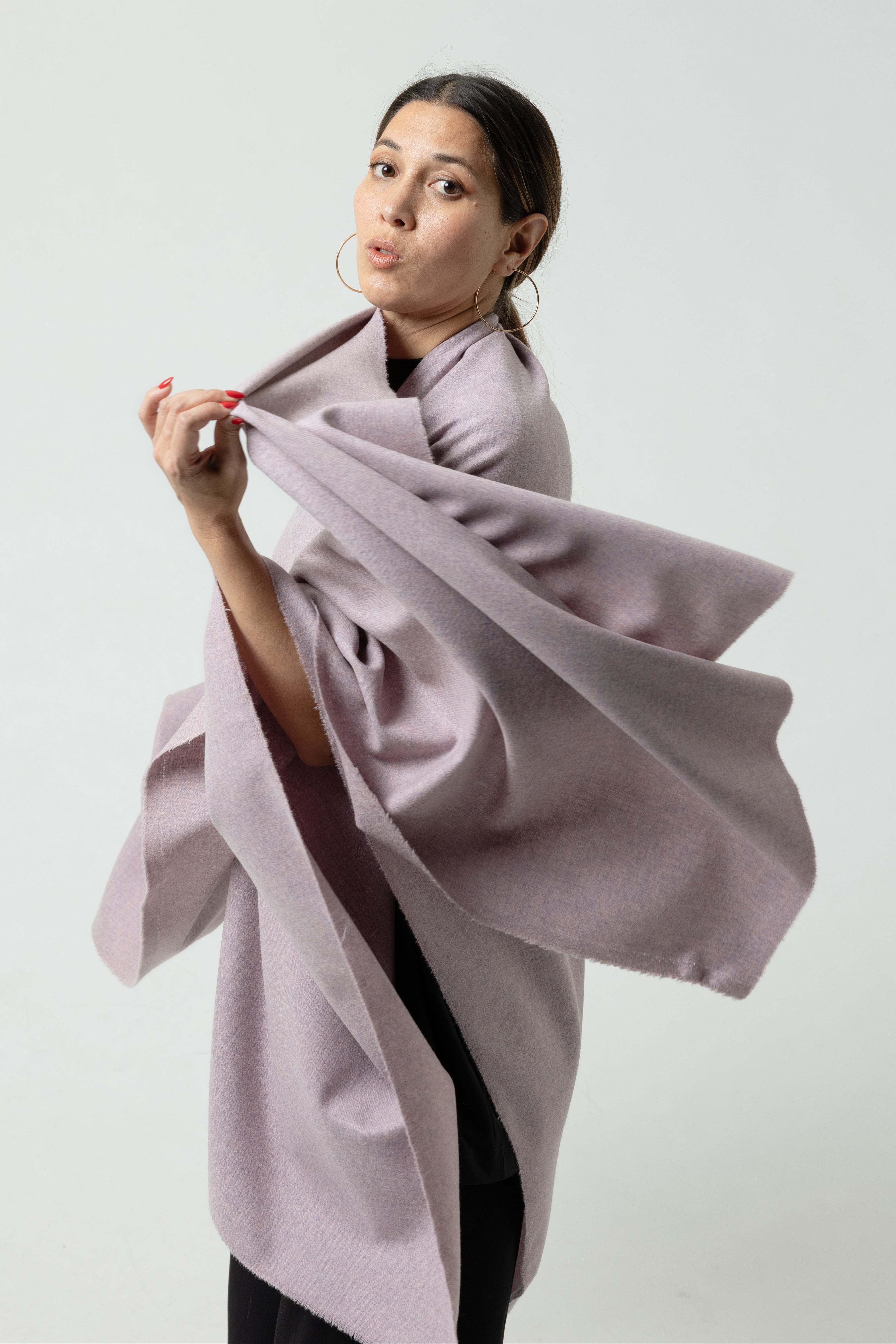 Woman holding a light purple coat against a white background