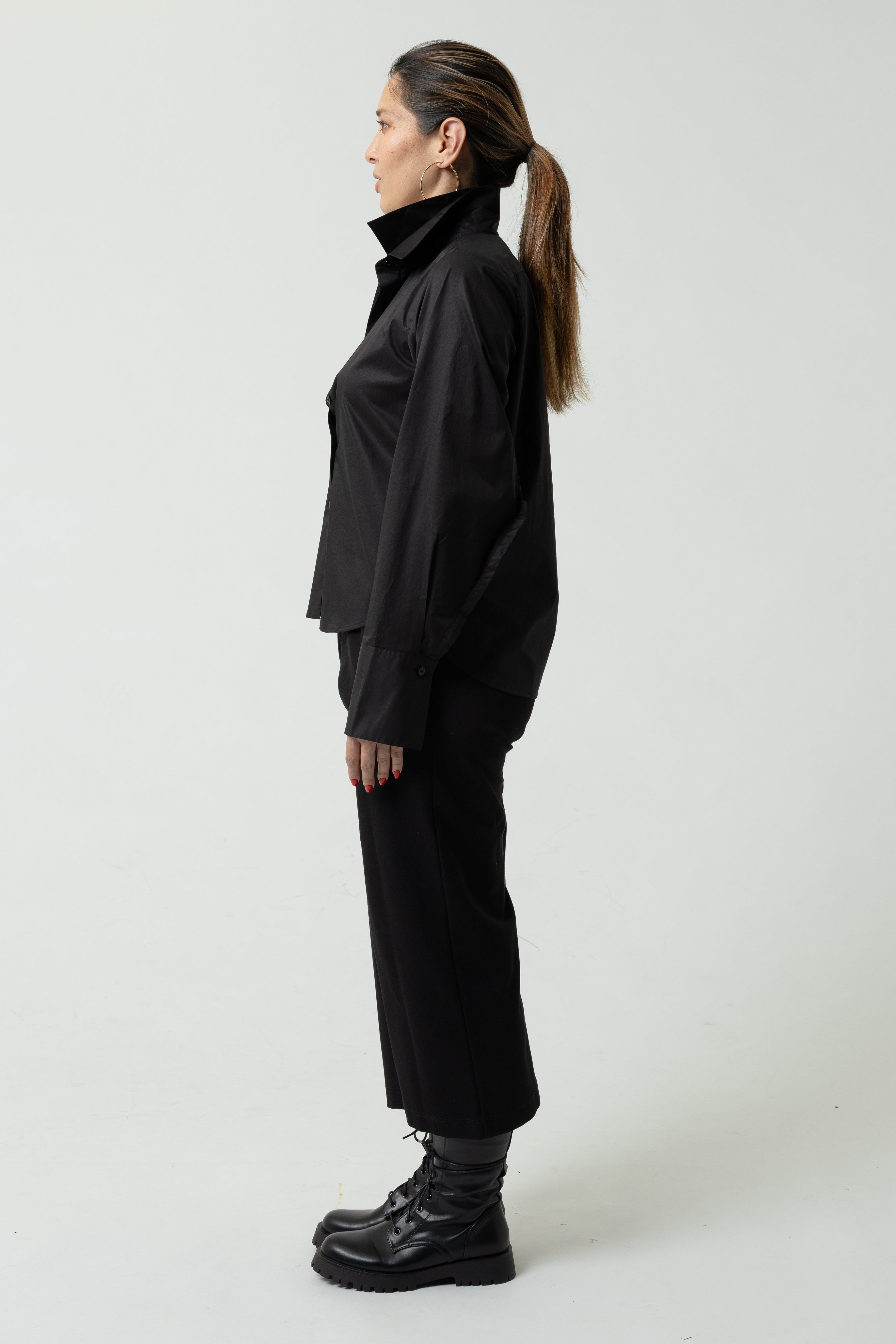 Person wearing a black outfit on a white background