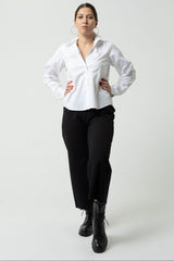 Person wearing a white shirt and black pants on a white background