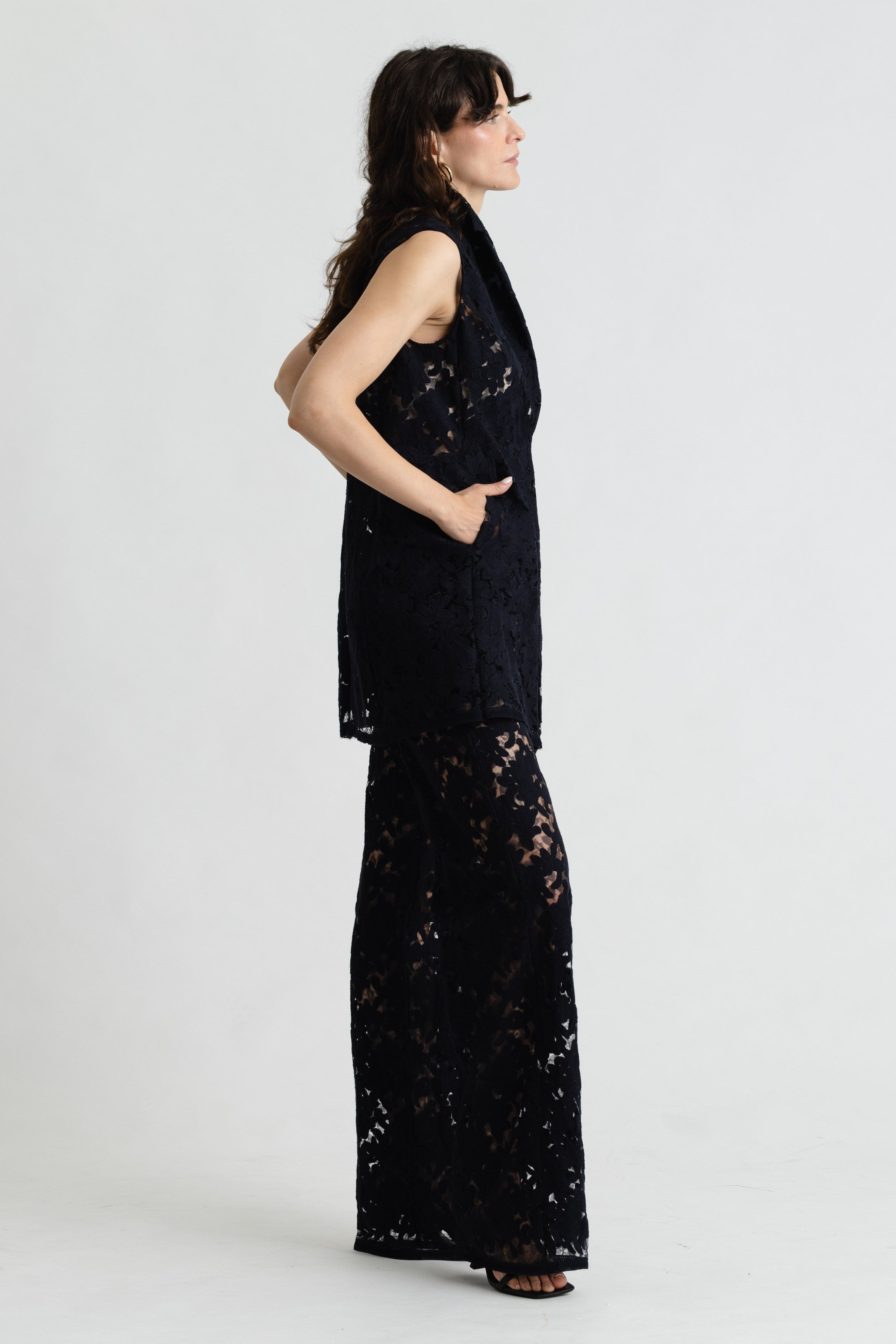 Woman wearing a black lace dress on a white background