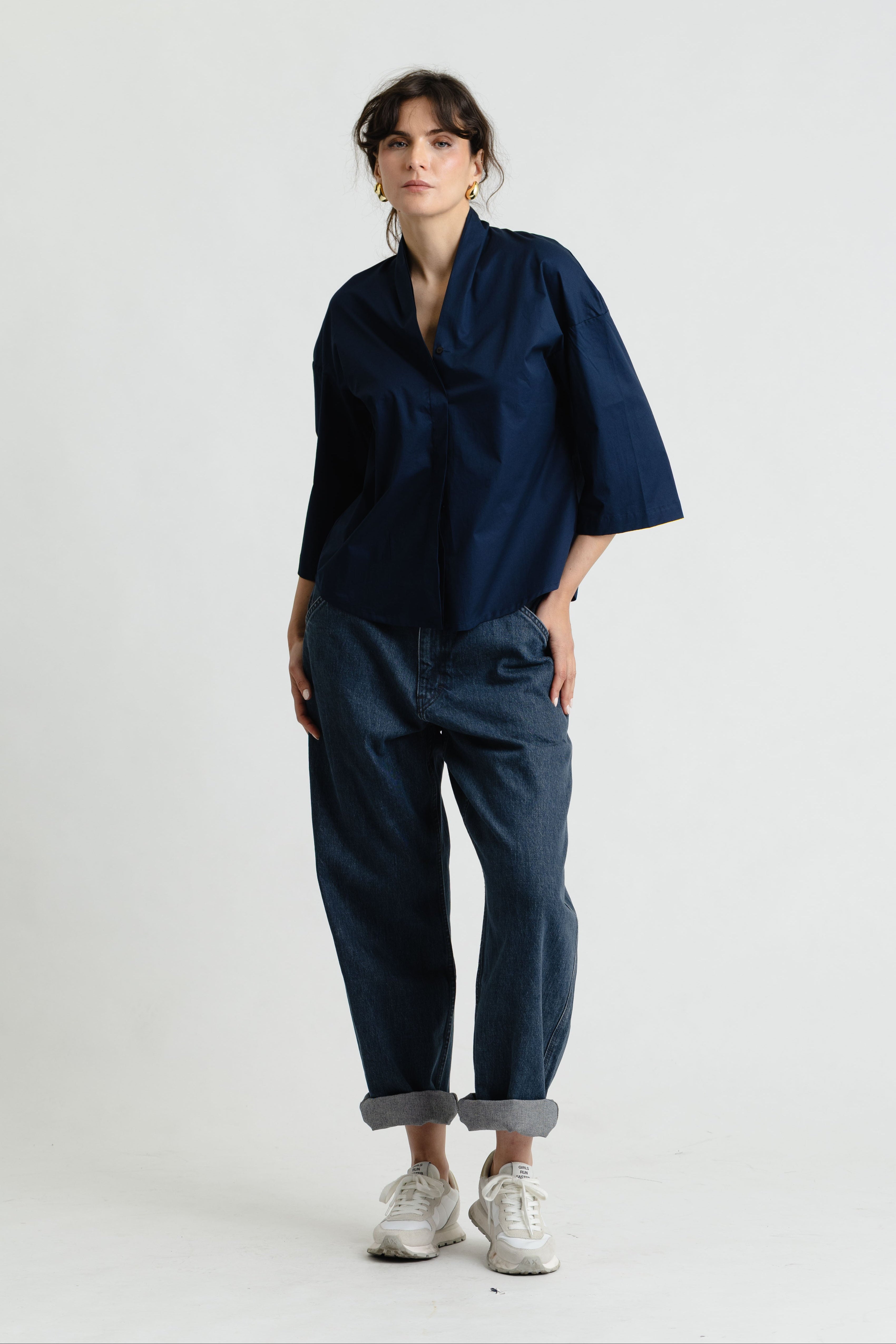 Person wearing a navy blue outfit with a white background