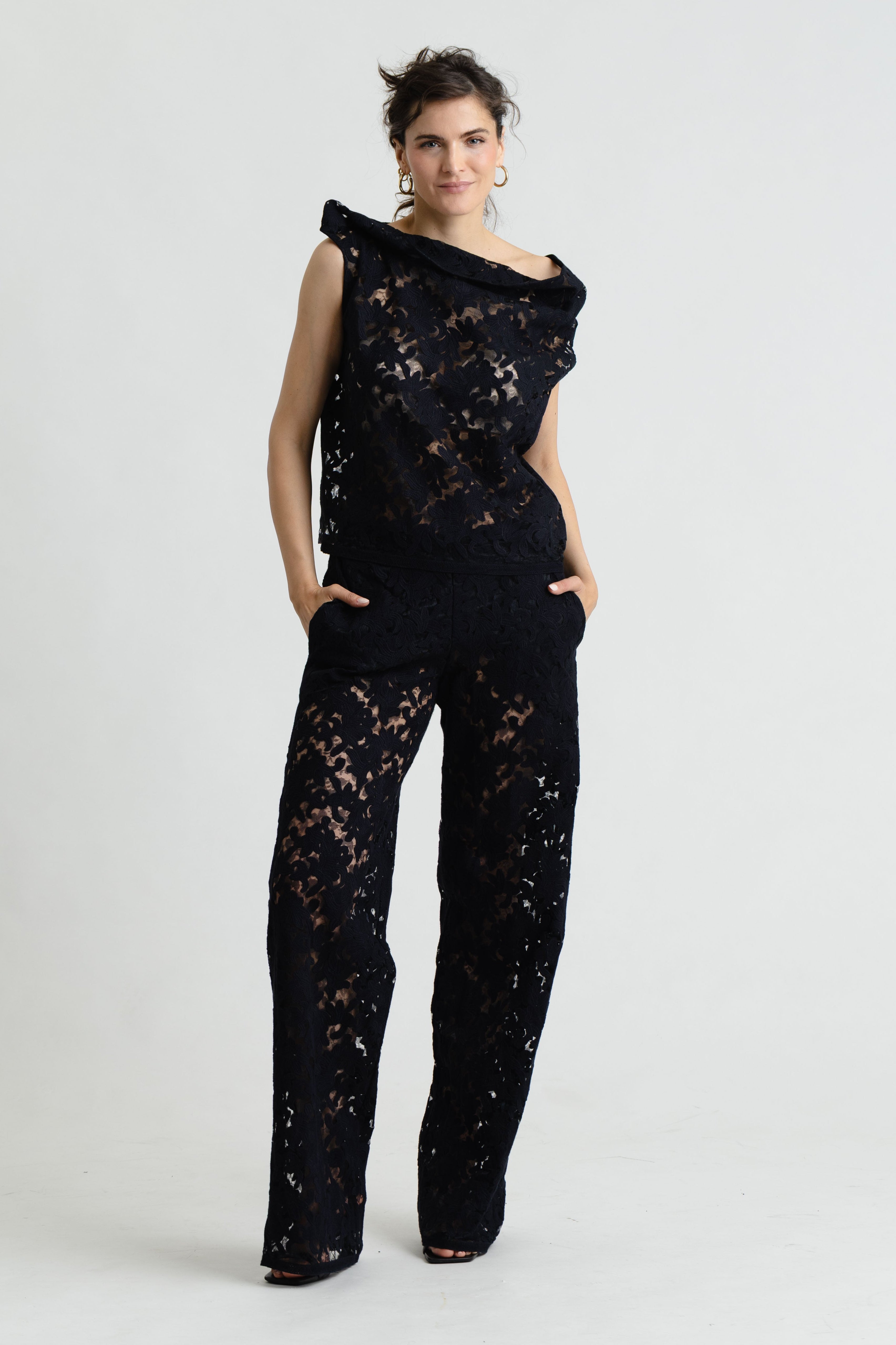 Woman wearing a black lace outfit on a white background