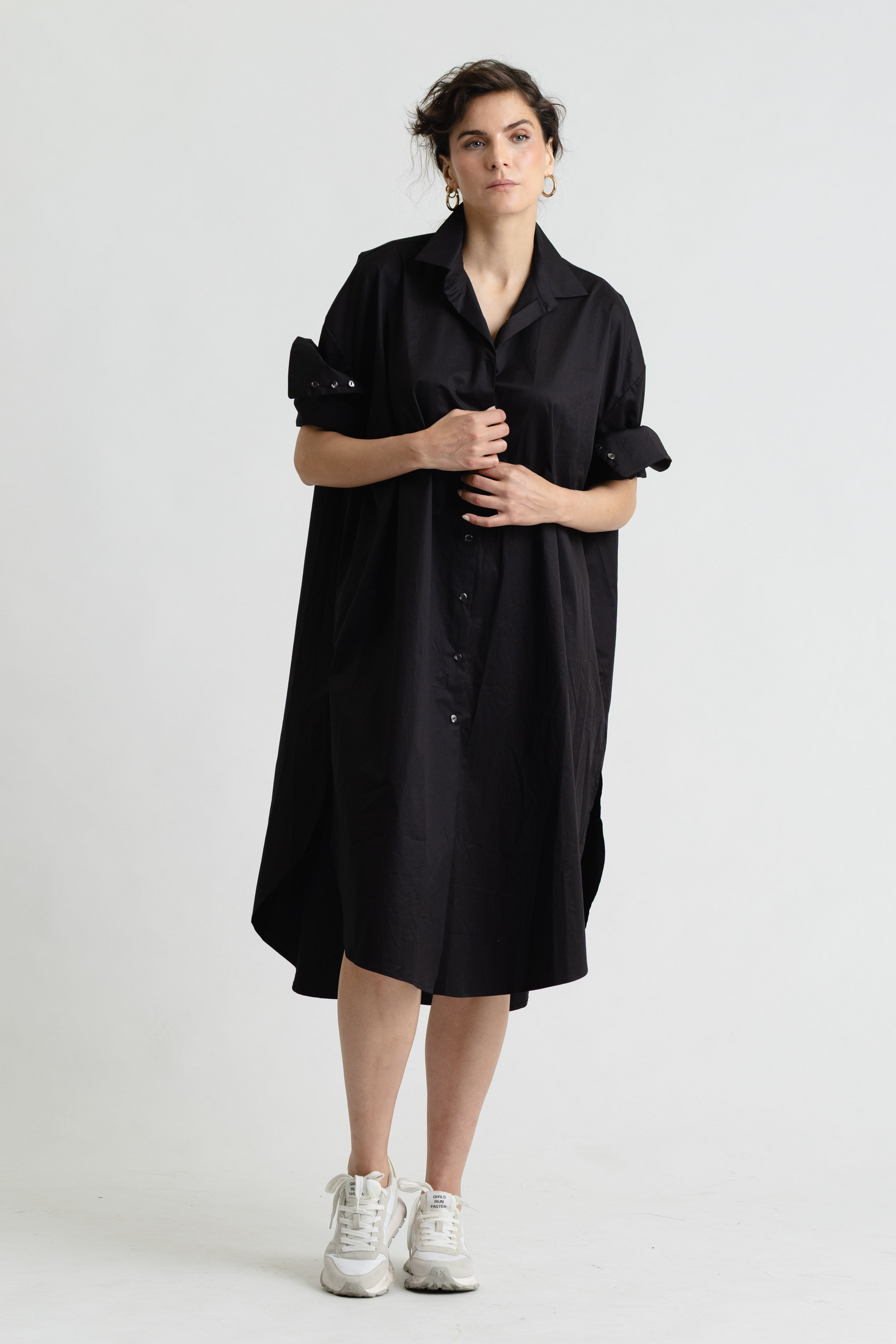 Person wearing a black dress with a white background