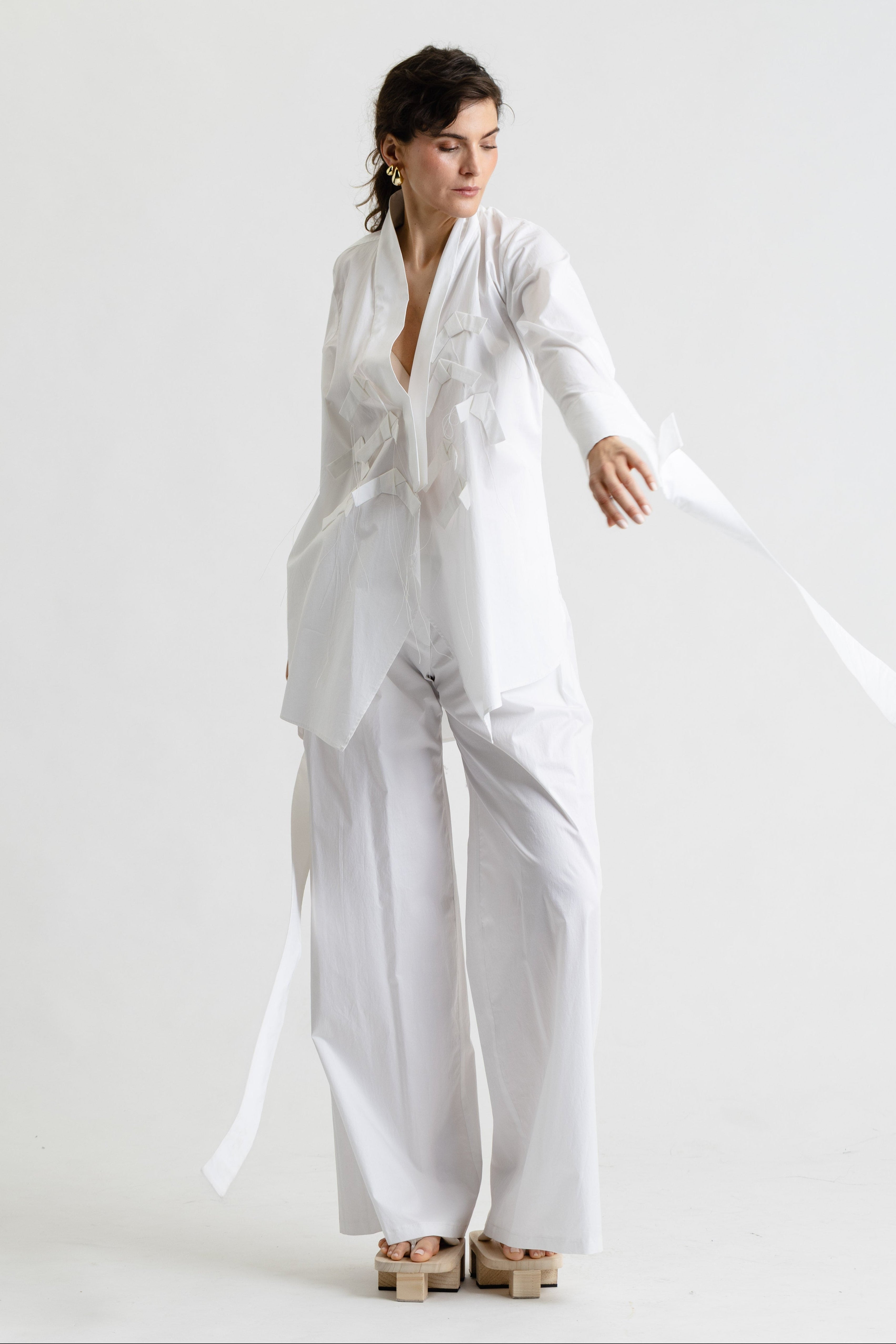 Woman wearing a white outfit on a plain background