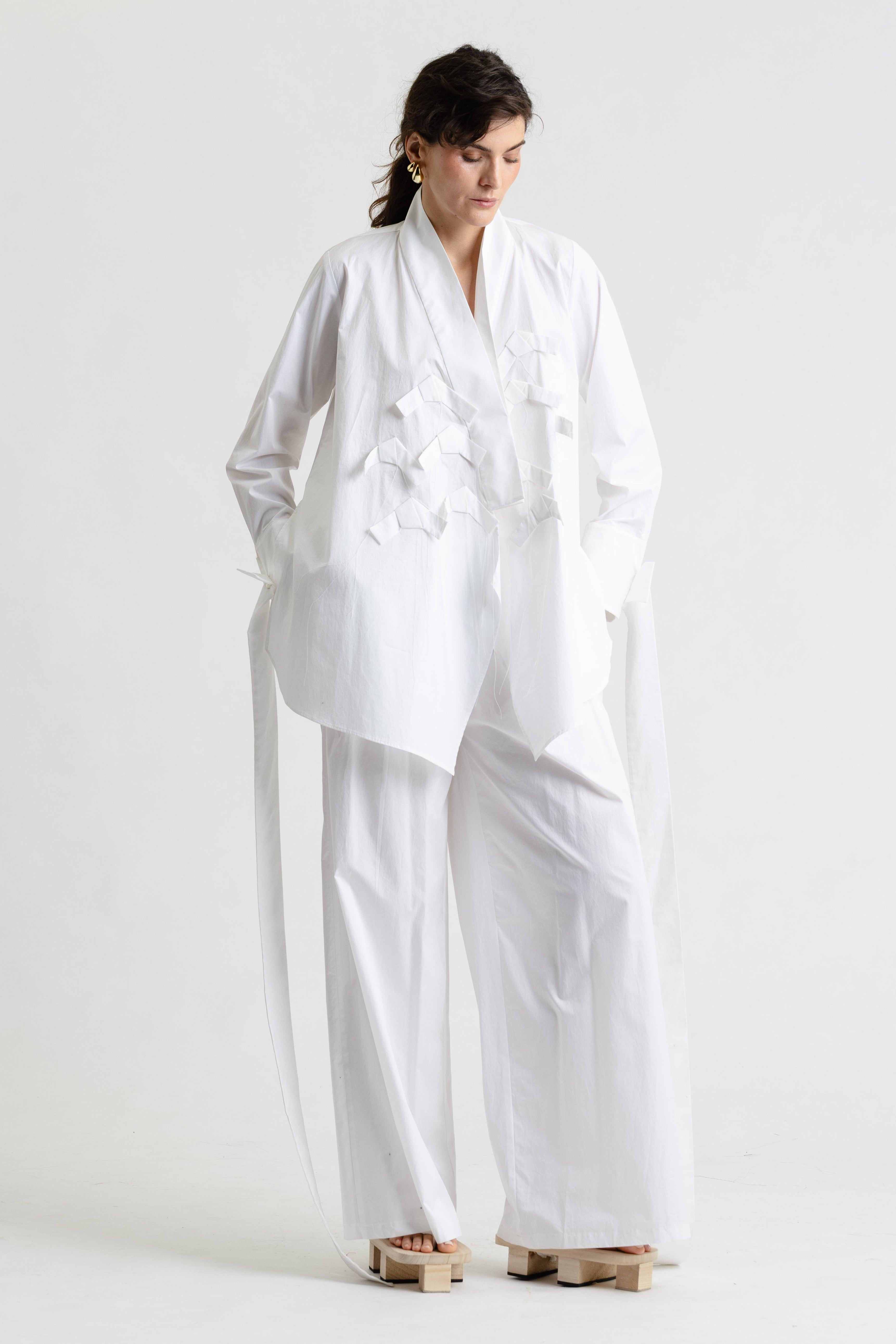 Woman wearing a white outfit on a plain background