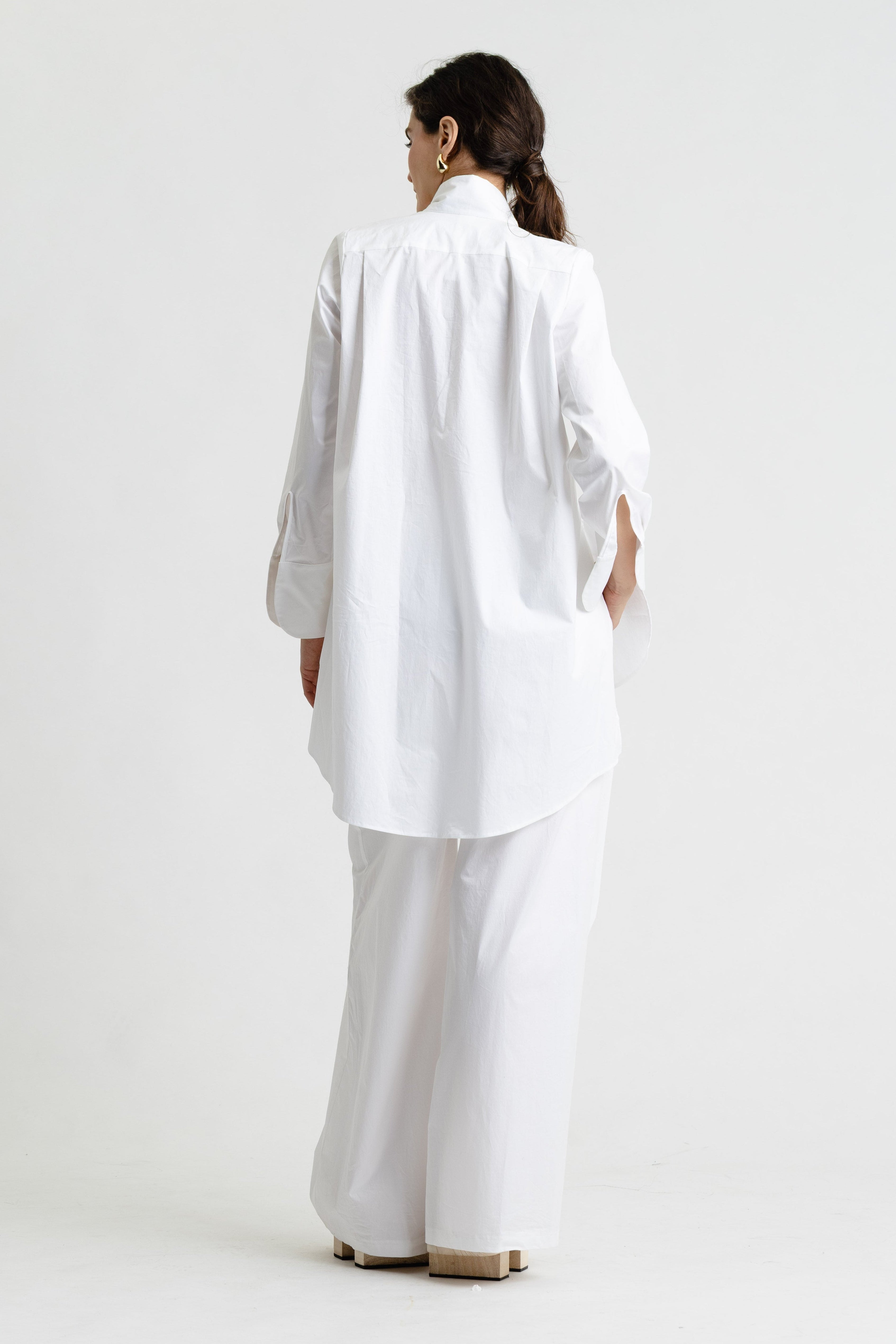 Person wearing a white outfit on a plain background