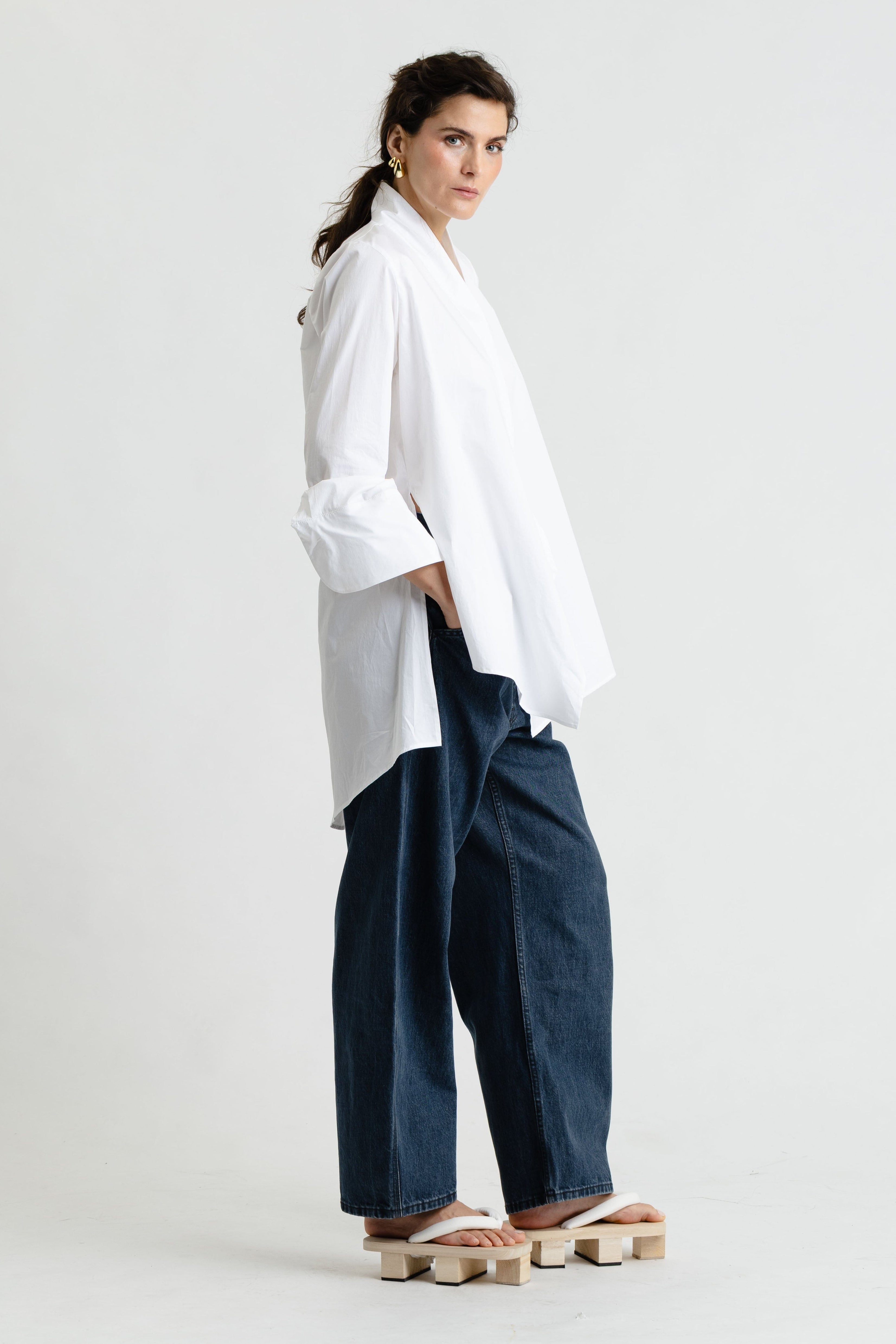 Person wearing a white shirt and blue pants on a white background