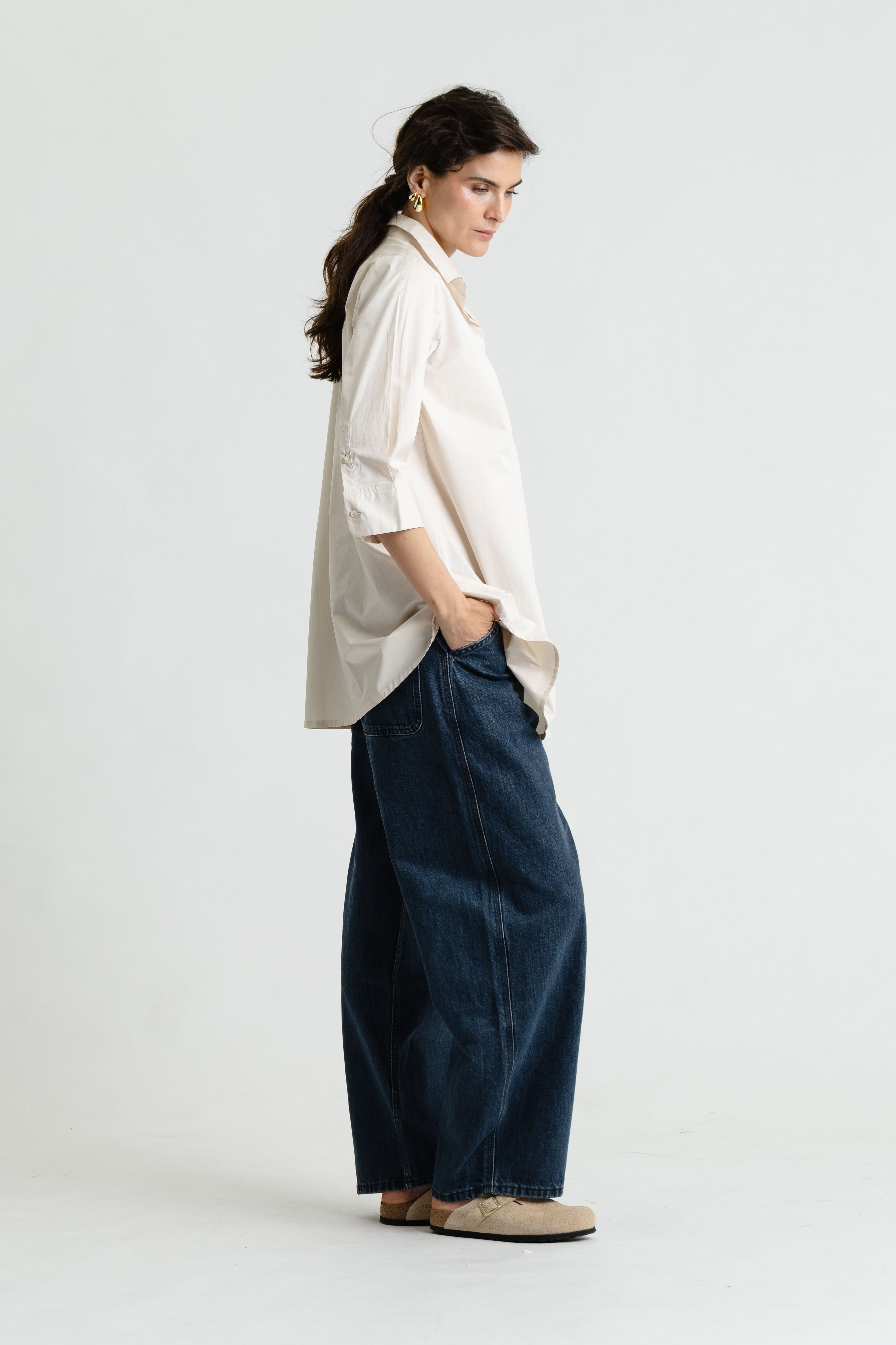 Person wearing a white shirt and dark blue pants on a white background