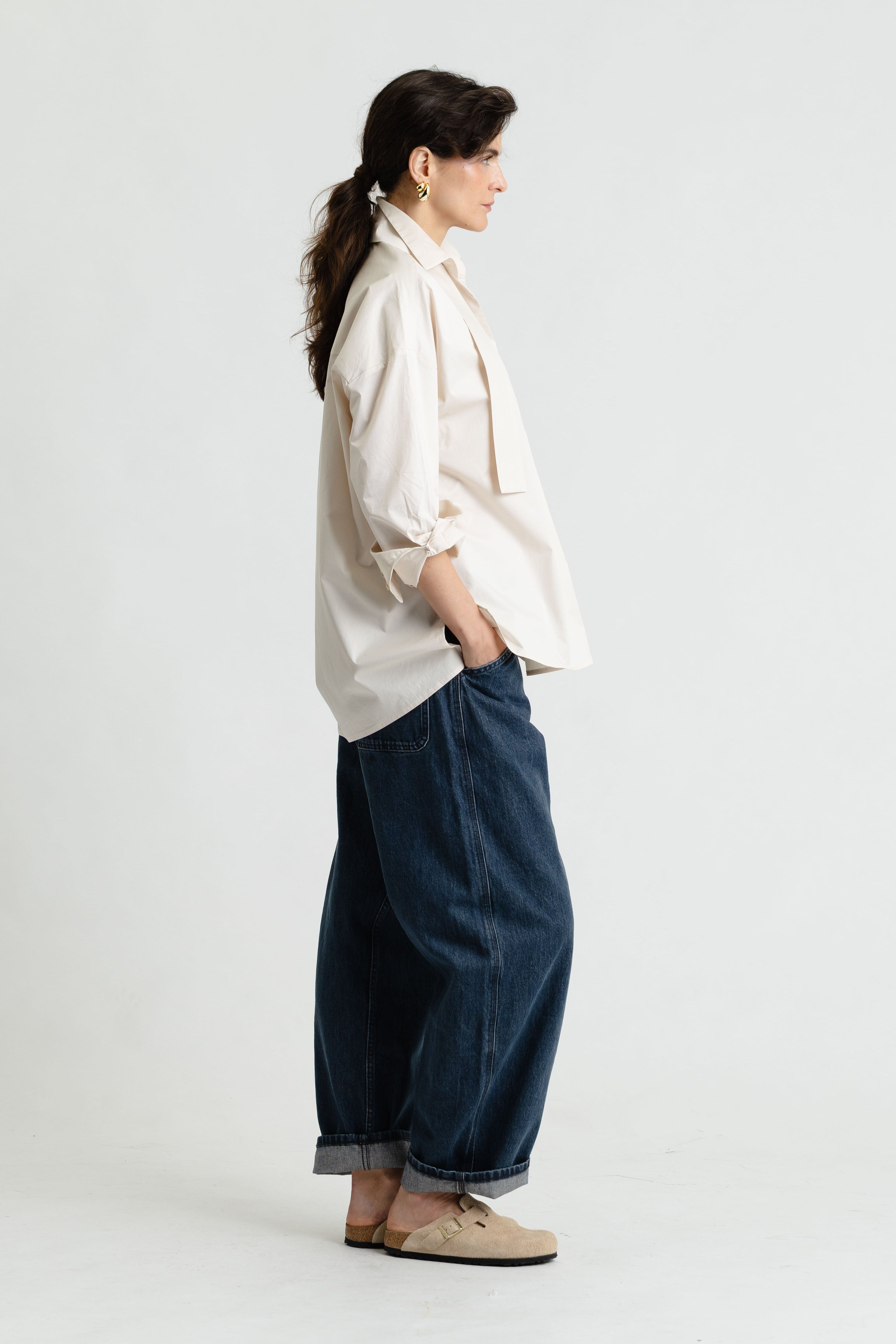 Person wearing a white shirt and blue pants on a white background