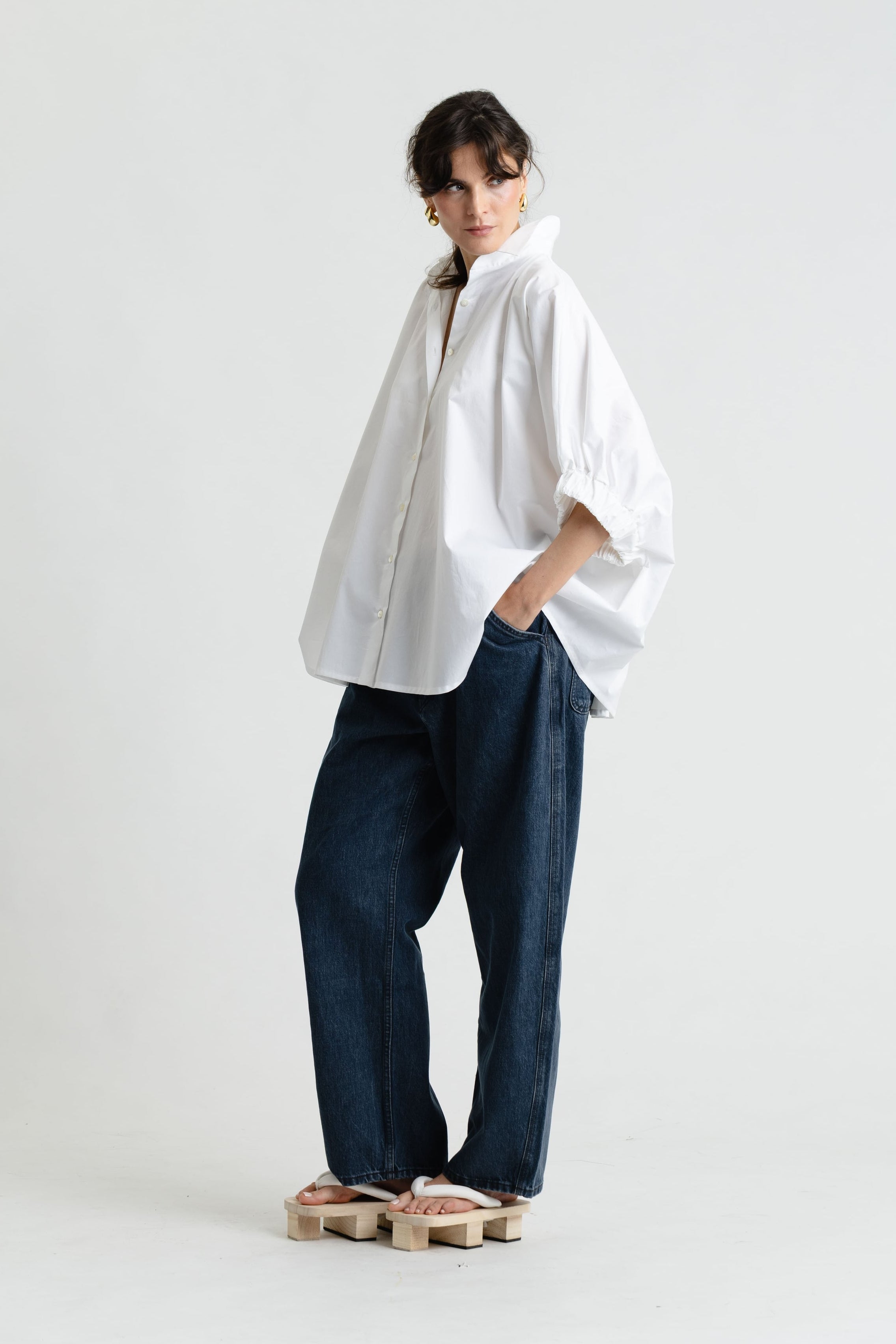 Person wearing a white shirt and blue jeans on a white background